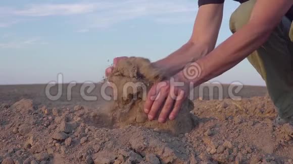 人类手握土尘的慢动作视频干旱无雨的土地视频的预览图