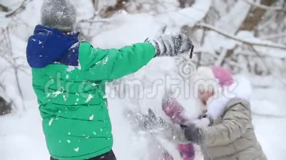 冬季森林穿着鲜艳衣服玩雪的孩子们视频的预览图