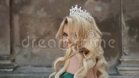 女孩金发穿着绿色连衣裙赤裸的肩膀戴着皇冠摆姿势拍照视频的预览图