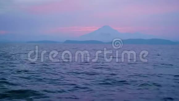 地平线上山景的粉红色日落和傍晚的海浪视频的预览图