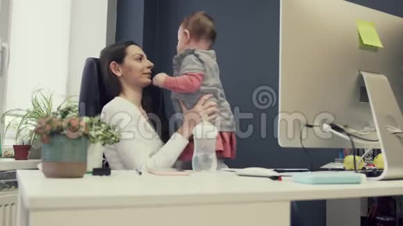 工作母亲与蹒跚学步的婴儿友好办公室工作成功的女企业家现代母亲视频的预览图