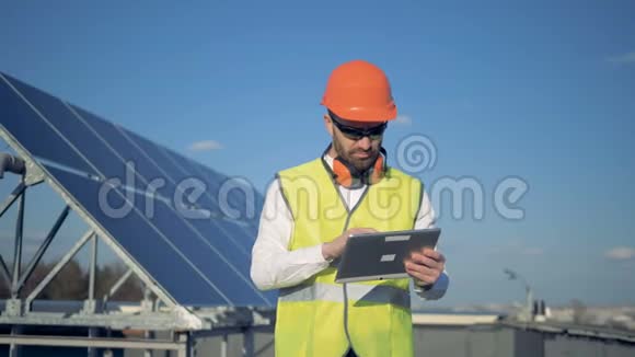 一名工人使用平板电脑数着屋顶上的太阳能电池板4公里视频的预览图