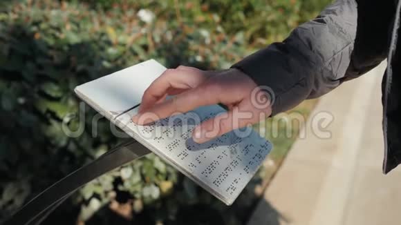 盲人女孩或男子阅读盲文字体写的文字阳光日街道板度假的人游客描述视频的预览图