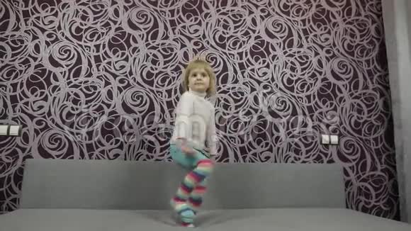 小快乐的孩子在沙发上跳舞听音乐视频的预览图