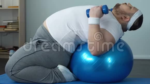 健身球瘦身计划上的有动机的胖男子举重哑铃视频的预览图