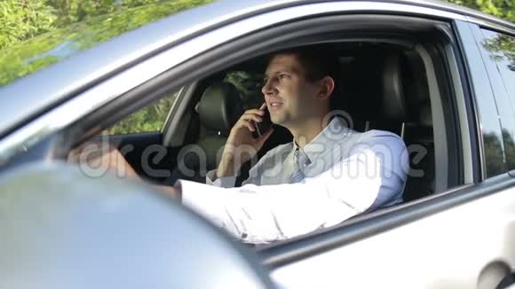 在车里成功的男人用手机说话视频的预览图