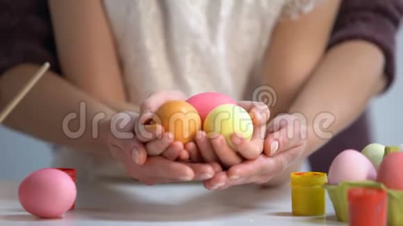 女儿和妈妈手里拿着五颜六色的彩蛋复活节艺术视频的预览图