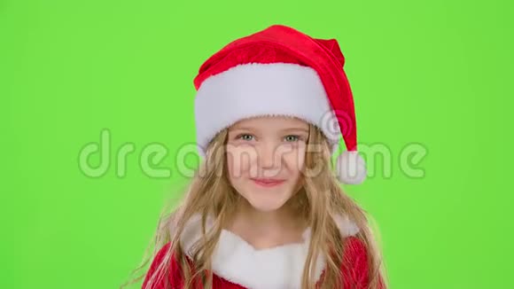 穿着漂亮西装戴着红色新年帽女孩微笑着绿色屏幕视频的预览图