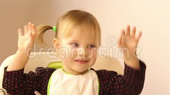 一个快乐的小女孩坐着挥舞着手臂视频的预览图