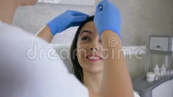 美容师在美容院用白铅笔在女孩脸上标记问题区域恢复程序视频的预览图