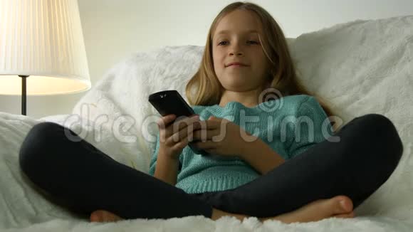 儿童看电视遥控女孩放松沙发生活教练视频的预览图