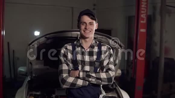 年轻英俊的汽车修理工在车间的肖像在服务的背景下汽车修理故障诊断视频的预览图