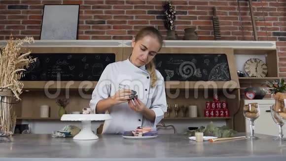 女面包师用酸奶油连接两半马卡龙视频的预览图