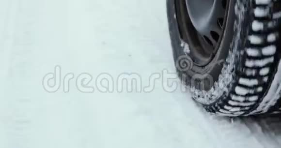 一辆车在森林道路上行驶在暴风雪中行驶视频的预览图