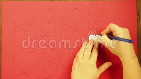 这个女孩画着一颗红色的纸板心特写视频的预览图
