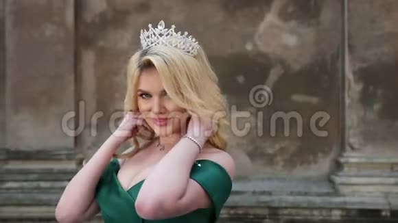 女孩金发穿着绿色连衣裙赤裸的肩膀戴着皇冠摆姿势拍照视频的预览图