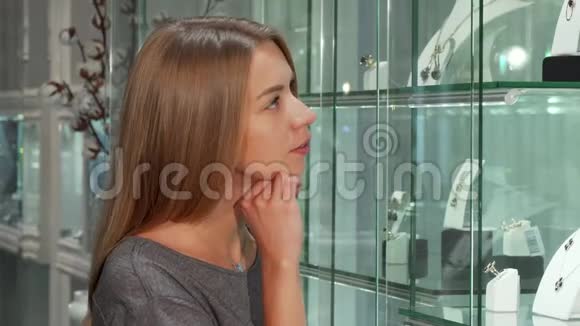 漂亮的年轻女性顾客在珠宝店检查陈列视频的预览图
