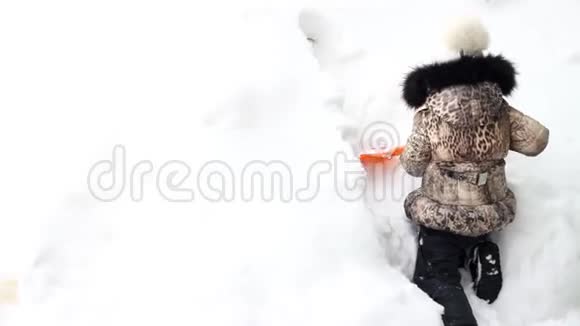 小女孩在挖雪铲多雪的冬天和大量的雪视频的预览图
