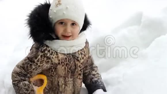 小女孩在挖雪铲很雪的冬天和很多雪视频的预览图