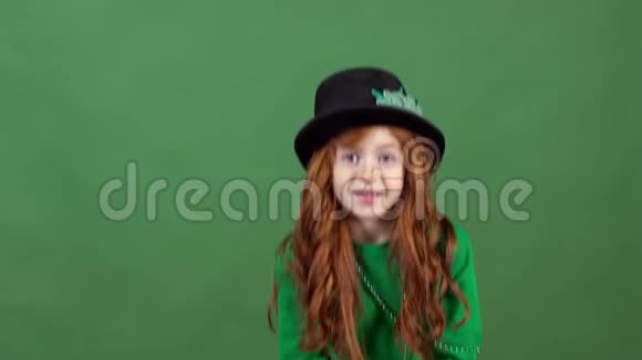 女孩红发庆祝圣帕特里克节绿墙背景投掷硬币视频的预览图