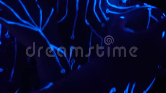 一个女孩在夜总会舞台上以外星形象舞蹈的形式在她的身体上画画视频的预览图