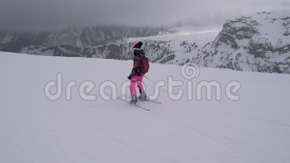 初学者滑雪女运动员正在举重运动员下面的斜坡上滑雪视频的预览图
