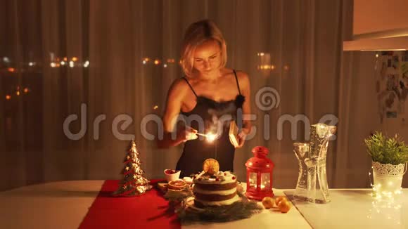 圣诞节那天晚上年轻女子在蛋糕上点燃了一个火花视频的预览图