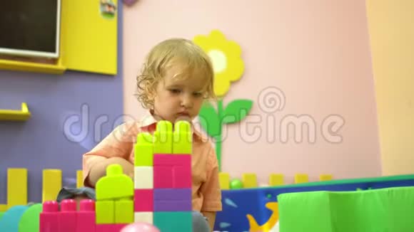 金发可爱的学龄前幼儿在幼儿园玩多种颜色的积木儿童发展视频的预览图