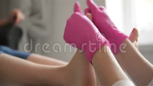 强壮的沙龙工人粉红橡胶手套加工腿中的集中大师在豪华美容中使用养护按摩视频的预览图