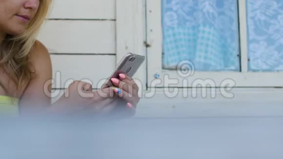 农村家庭户外露台上使用手机的美女视频的预览图