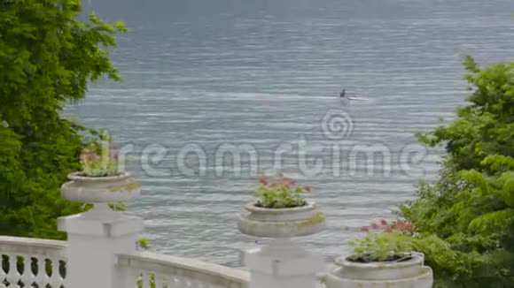 夏季从酒店露台欣赏湖景行动夏天的湖在皮艇上和男人一起经过视频的预览图