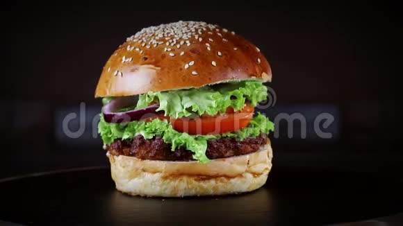 带有切块的汉堡在黑色背景的木板上旋转视频的预览图