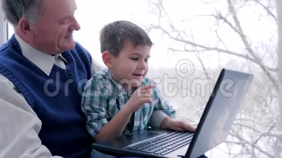 退休老人上网娱乐孙子与爷爷在家玩电脑网络游戏视频的预览图