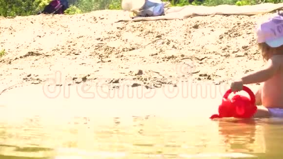 在河边沙滩上玩水壶的女孩视频的预览图