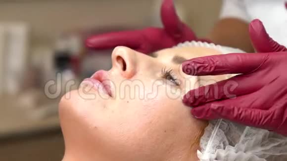 美容师在眼睛下面擦皮肤霜在眼睛下面涂上护肤霜视频的预览图