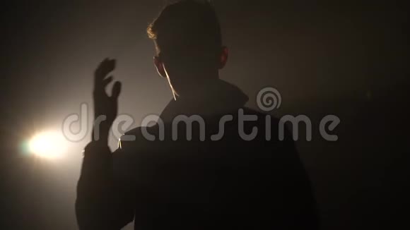 一个男舞者跳舞和整理发型的剪影视频的预览图