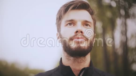 4K一个自信微笑的欧洲男人的肖像关闭低角度拍摄长胡子的帅哥正眼看着前方视频的预览图