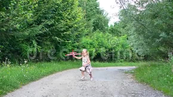 可爱的小女孩在公园玩飞机玩具在日落黄金时间儿童天真的游戏观念慢视频的预览图
