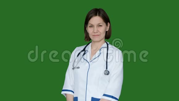 微笑自信的女医生穿着实验室外套看着绿色屏幕上的相机色度键视频的预览图