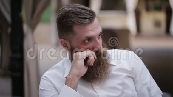 一个留胡子的人在一家夏季餐厅视频的预览图