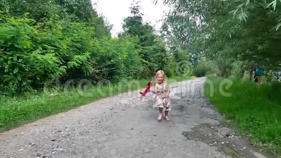 可爱的小女孩在公园玩飞机玩具在日落黄金时间童年天真玩概念慢视频的预览图