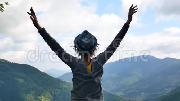 女孩站起来双臂放在腰间望着山顶上的地平线视频的预览图