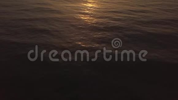 金色的太阳反射在海水表面而早晨的日出鸟瞰在水波荡漾的水面上飞翔的无人机视频的预览图