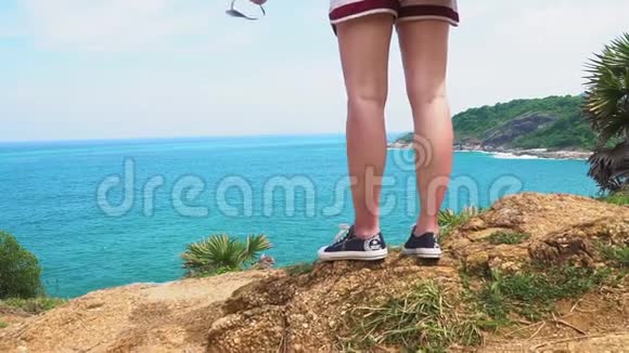 旅游女孩站在热带海边的岩石上视频的预览图