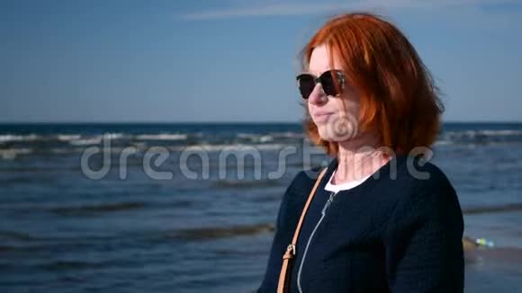 戴墨镜的女人欣赏大海和大海的肖像视频的预览图