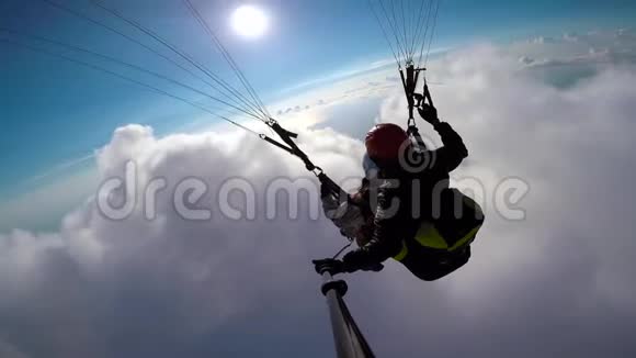 在天空云层和天际线景观中人滑翔伞在空中飞行角度自拍动作相机滑翔伞视频的预览图