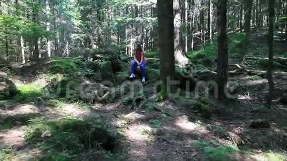 在森林里坐在石头上的少女视频的预览图
