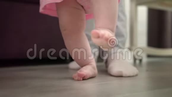 小宝宝学走路在地板上婴儿与父亲一起迈出第一步视频的预览图