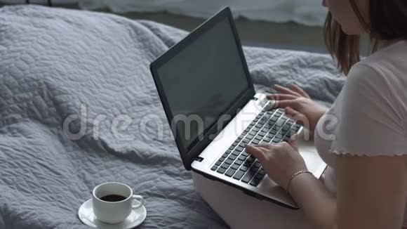 在床上写手提电脑博客的积极女性视频的预览图
