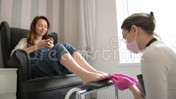强壮的沙龙工人粉红橡胶手套加工腿中的集中大师在豪华美容中使用养护按摩视频的预览图